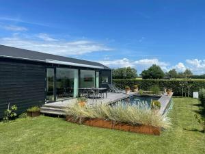 a house with a deck and a swimming pool at Holiday Home With Panoramic Views And Nature Pool in Harpelunde +15 photos