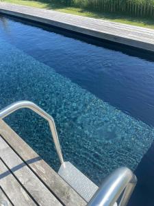 a swimming pool with a chair in the water at Holiday Home With Panoramic Views And Nature Pool in Harpelunde