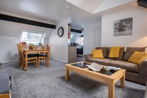 una sala de estar con un sofá y una mesa en Old Stables Loft, en Kendal