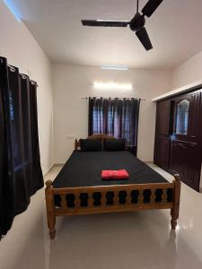 Un dormitorio con una cama y un ventilador de techo. en villa mud apples, en Varkala
