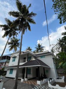 Un edificio con palmeras delante. en villa mud apples, en Varkala 2 fotos más