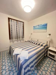 a bedroom with two beds with blue and white stripes at Casa Smeraldo in Cavo