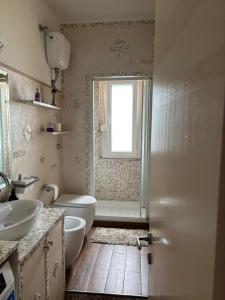 a bathroom with a sink and a toilet and a window at Appartamenti "Venus" a Marina Julia per 4 o 6 persone in Marina Julia +34 photos