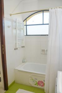 a white bathroom with a tub and a window at Posada Los Angelos in Ramallo +37 photos