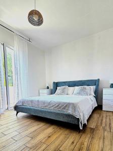 a bedroom with a blue bed and a wooden floor at Casa Marispica in Ispica