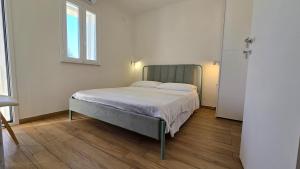 a bedroom with a bed in a white room at Casa Marispica in Ispica