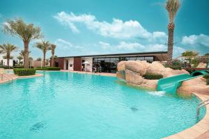 a swimming pool with a slide in a resort at Upscale 4BR Villa, Bali Pool, Resort Escape in Dubai