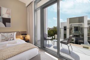 a bedroom with a bed and a balcony at Upscale 4BR Villa, Bali Pool, Resort Escape in Dubai