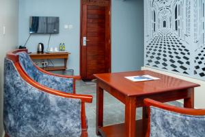 a dining room with a wooden table and chairs at The Mark Hotel in Ruiru