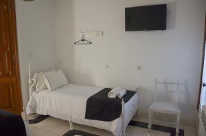 a small bedroom with a bed and a tv on the wall at Posada Los Angelos in Ramallo