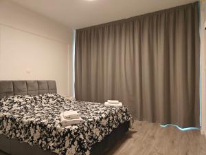 a bedroom with a bed with a black and white blanket at Brand new sea view walking distance to the sea 200m in Limassol +10 photos