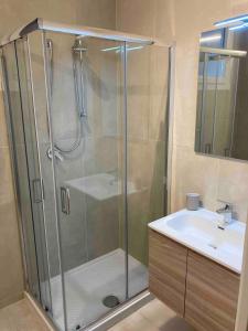 a shower with a glass door next to a sink at casa mare in Cattolica