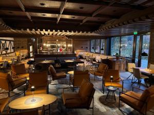 a restaurant with tables and chairs and a bar at Das Dreiburgensee Naturhotel & Spa im Bayrischen Wald in Thurmansbang