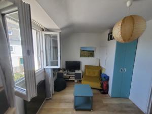 een woonkamer met een gele stoel en een raam bij Bel appartement centre Le Palais in Le Palais