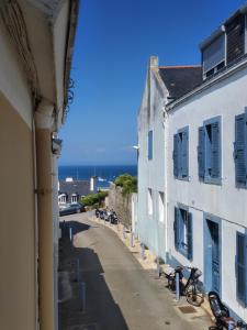 een straat met twee witte gebouwen en de oceaan bij Bel appartement centre Le Palais in Le Palais