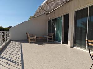 a patio with chairs and a table on a building at Brand new sea view walking distance to the sea 200m in Limassol