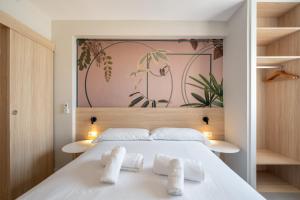 ein Schlafzimmer mit einem weißen Bett und zwei weißen Handtüchern in der Unterkunft Mara Boutique Apartments in Benidorm