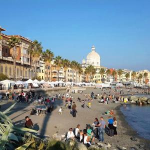 a group of people sitting on a beach near the water at L'oasi di relax in Genova