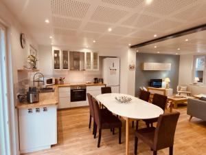 a kitchen and dining room with a table and chairs at La Parenthèse Marine in Étaples