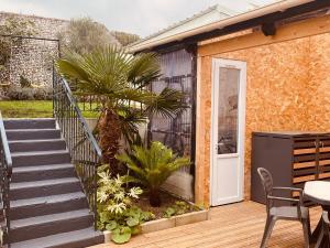 a patio with a staircase and a palm tree at La Parenthèse Marine in Étaples