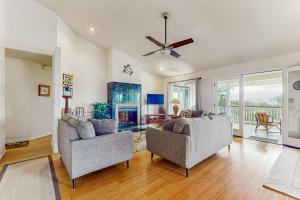 a living room with two chairs and a fireplace at Hale ʻAina Kai in Kuhio Village