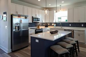 a kitchen with a refrigerator and a counter with stools at Bay to Breakers in Fort Morgan