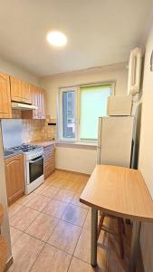 a kitchen with a refrigerator and a table and a window at Mieszkanie przy Parku in Łomża