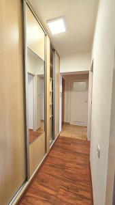 an empty hallway with mirrors and wood floors at Mieszkanie przy Parku in Łomża
