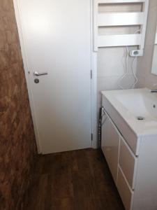 a bathroom with a sink and a white door at Beach House - Casa de praia, Costa in Almograve +26 photos