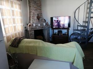 a living room with a tv and a fireplace at Beach House - Casa de praia, Costa in Almograve