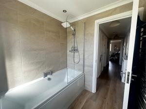 a bathroom with a white tub and a shower at Castle View, Cosy Stay in Strood