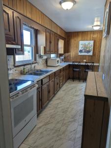 a large kitchen with wooden cabinets and a sink at Hot Tub Hideaway Near Ste Genevieve in Saint Mary