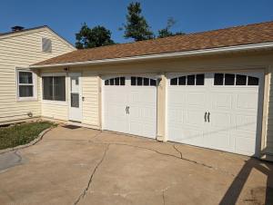 a house with two garage doors in a driveway at Hot Tub Hideaway Near Ste Genevieve in Saint Mary