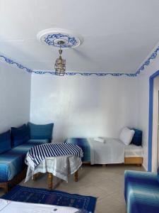 シェフシャウエンにあるDar Alamiのベッド2台とソファ1台とテーブル1台がある部屋