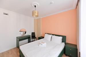 una camera da letto con un letto e una scrivania con uno specchio di Sunset Apartaments - Sunflower a Toruń