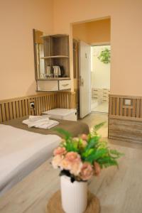 a bedroom with a bed and a vase with flowers at MarNar Hotel in Yerevan