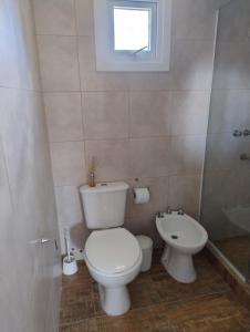 un baño con inodoro y lavabo en Apart Atlántida, en Santa Clara del Mar