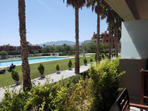 a view of a resort with palm trees and a swimming pool at Precioso piso a 10 min de la playa in Vera