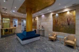 a lobby with a blue couch and two chairs at Eurostars Rey Alfonso X in Ciudad Real