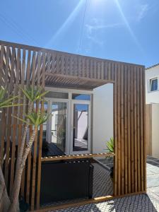 a house with a wooden fence and a palm tree at Casa Juli Cascais in Alcabideche