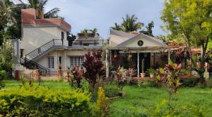 a house with a garden in front of it at Green Leaf Nature HomeStay in Santaveri