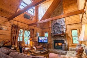 a living room with a fireplace in a log cabin at 2 Cubs Cabin in Blowing Rock +29 photos