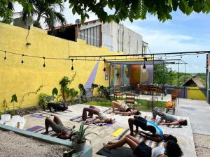 a group of people doing yoga in front of a building at La Embajada Bacalar in Bacalar