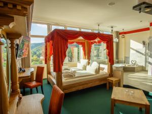 a bedroom with a canopy bed and a large window at Hasseröder Burghotel in Wernigerode
