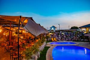 a resort with a pool and tables and chairs at Avian Court Hotel in Naivasha