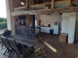 a kitchen with a table and chairs in a room at Gite Le Marquès in Coueilles