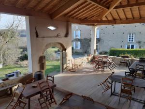a patio with tables and chairs and a building at Gite Le Marquès in Coueilles