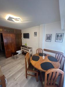 Una habitación con una mesa y sillas y un televisor. en Amplio monoambiente subdividido zona centro, en Pinamar