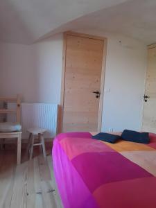 Un dormitorio con una cama grande con una manta morada. en Gite du lézard, en Saint-Disdier-en-Dévoluy