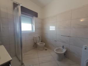 a white bathroom with a toilet and a sink at Casa do Doque in Vila Nova de Foz Coa +9 photos